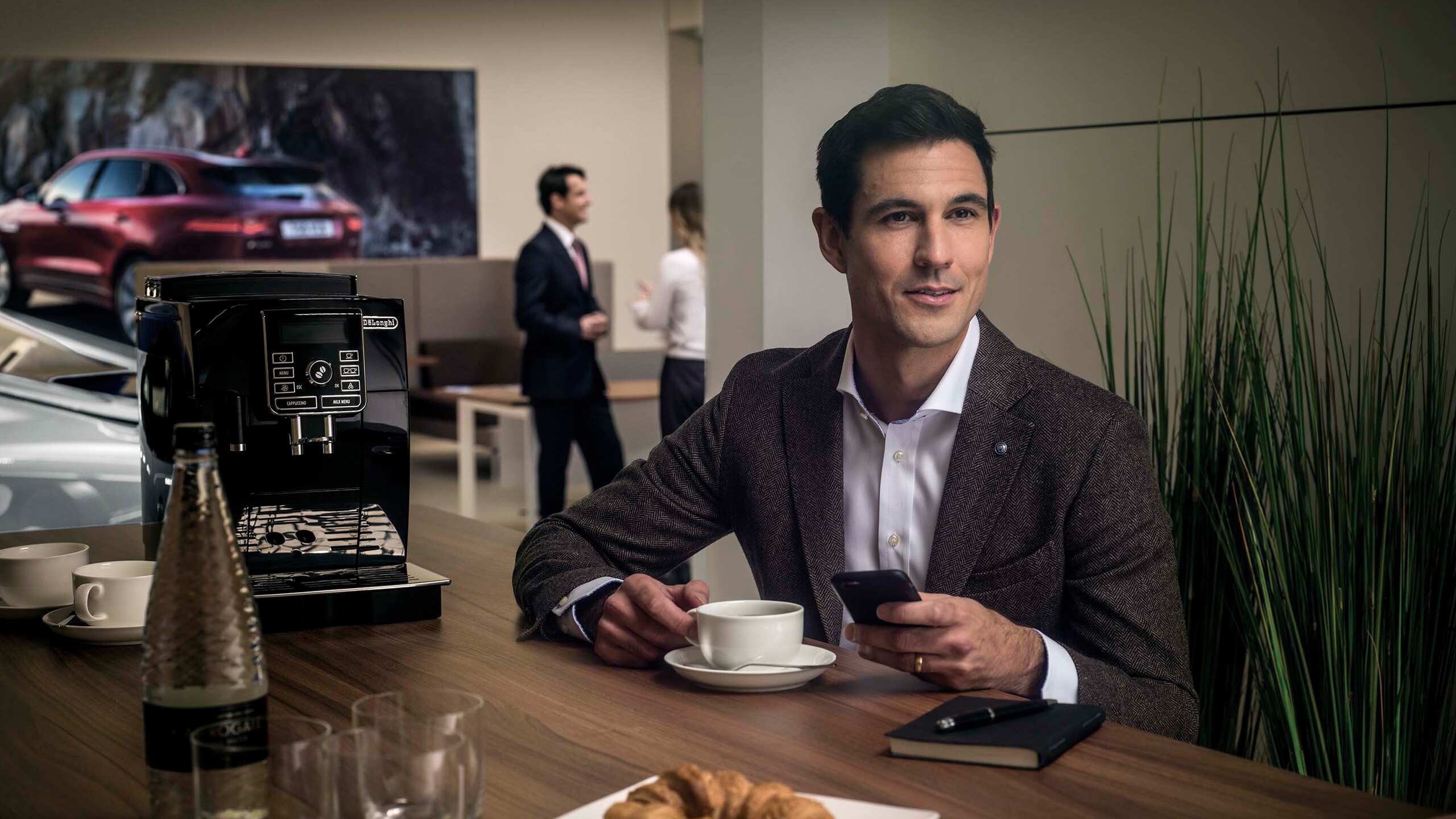 A person having tea in Jaguar showroom