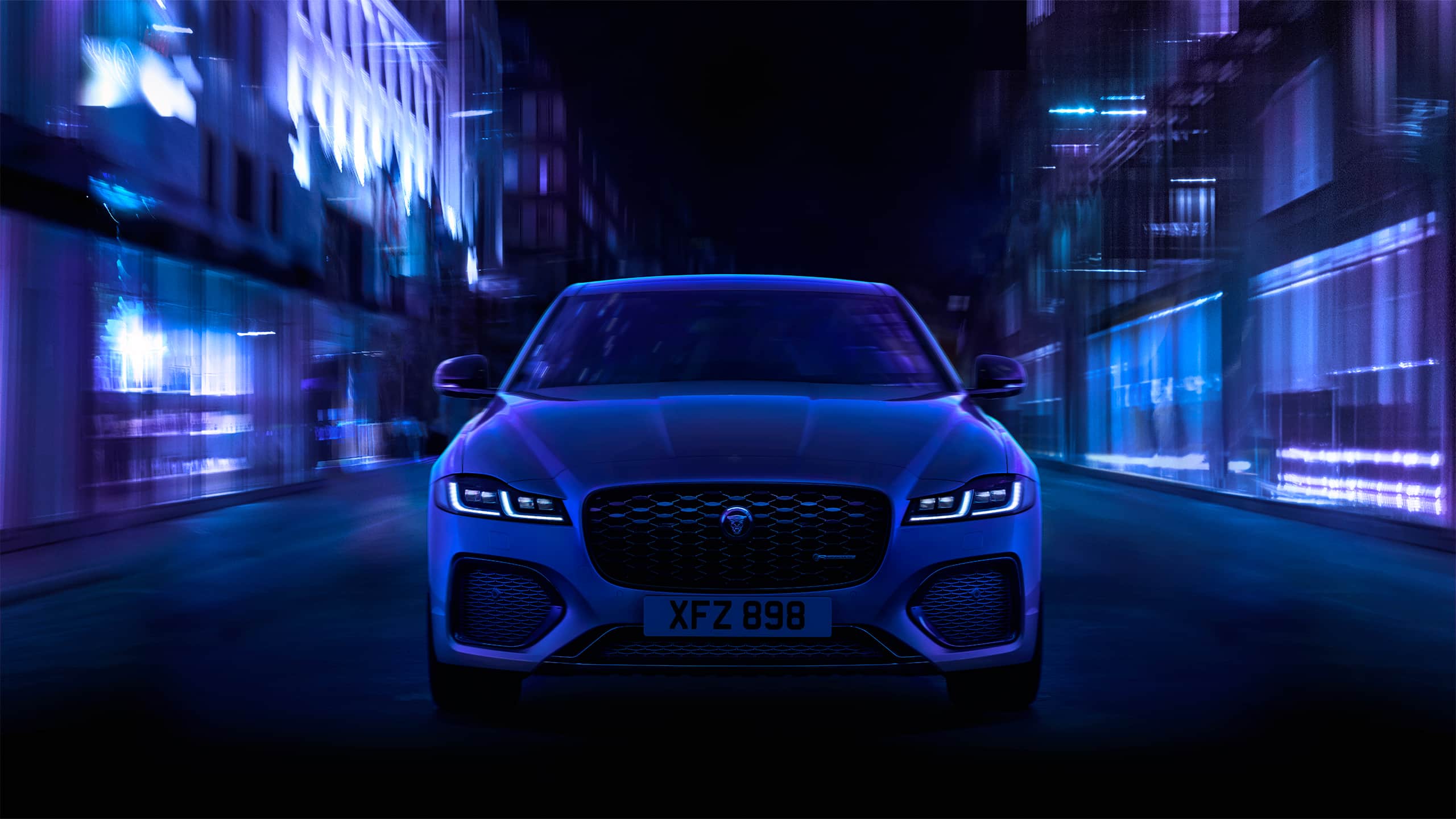 The front angle of a Jaguar XF as it drives through a city