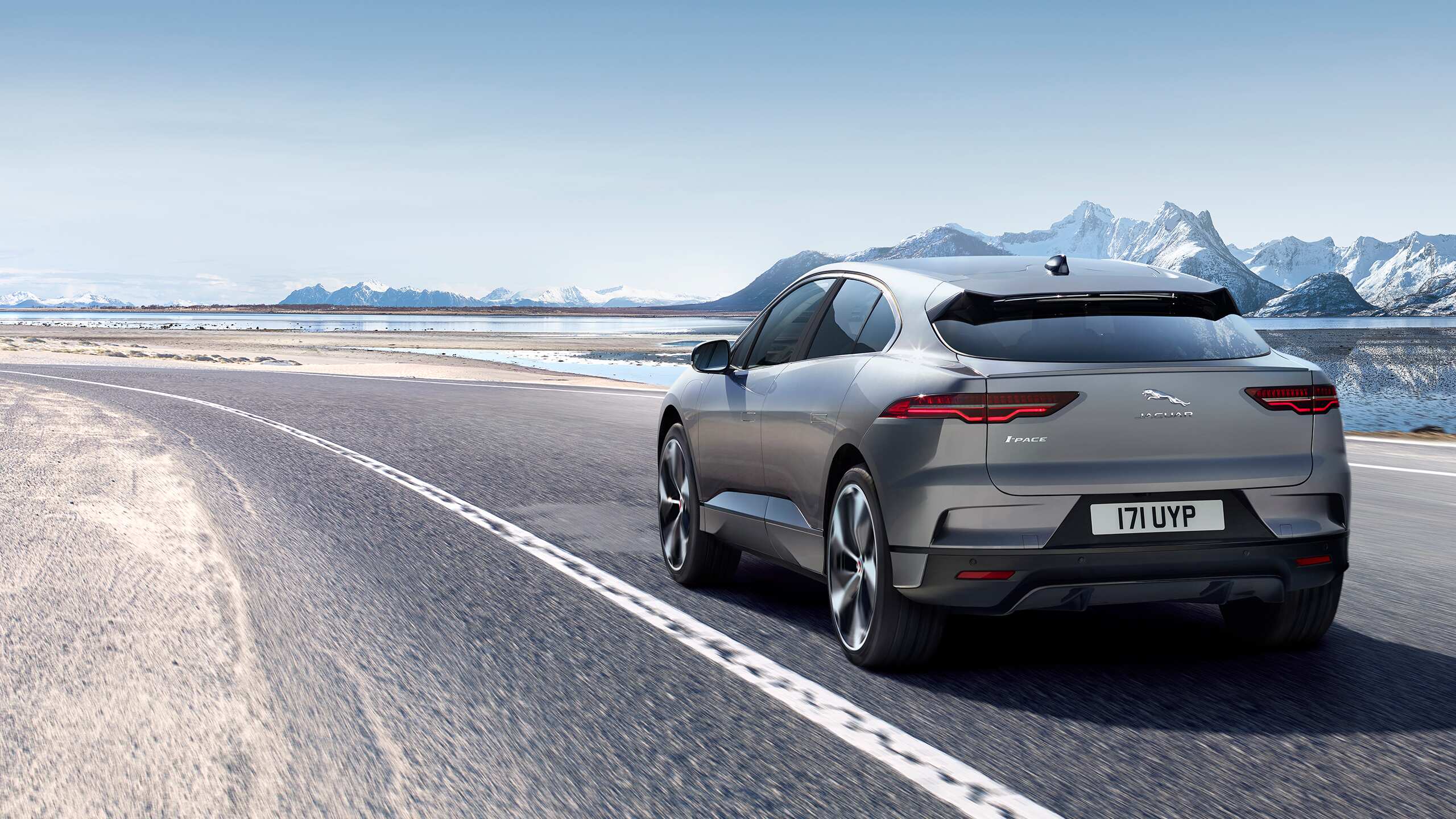 Jaguar I-Pace running on the road and with ice mountain background