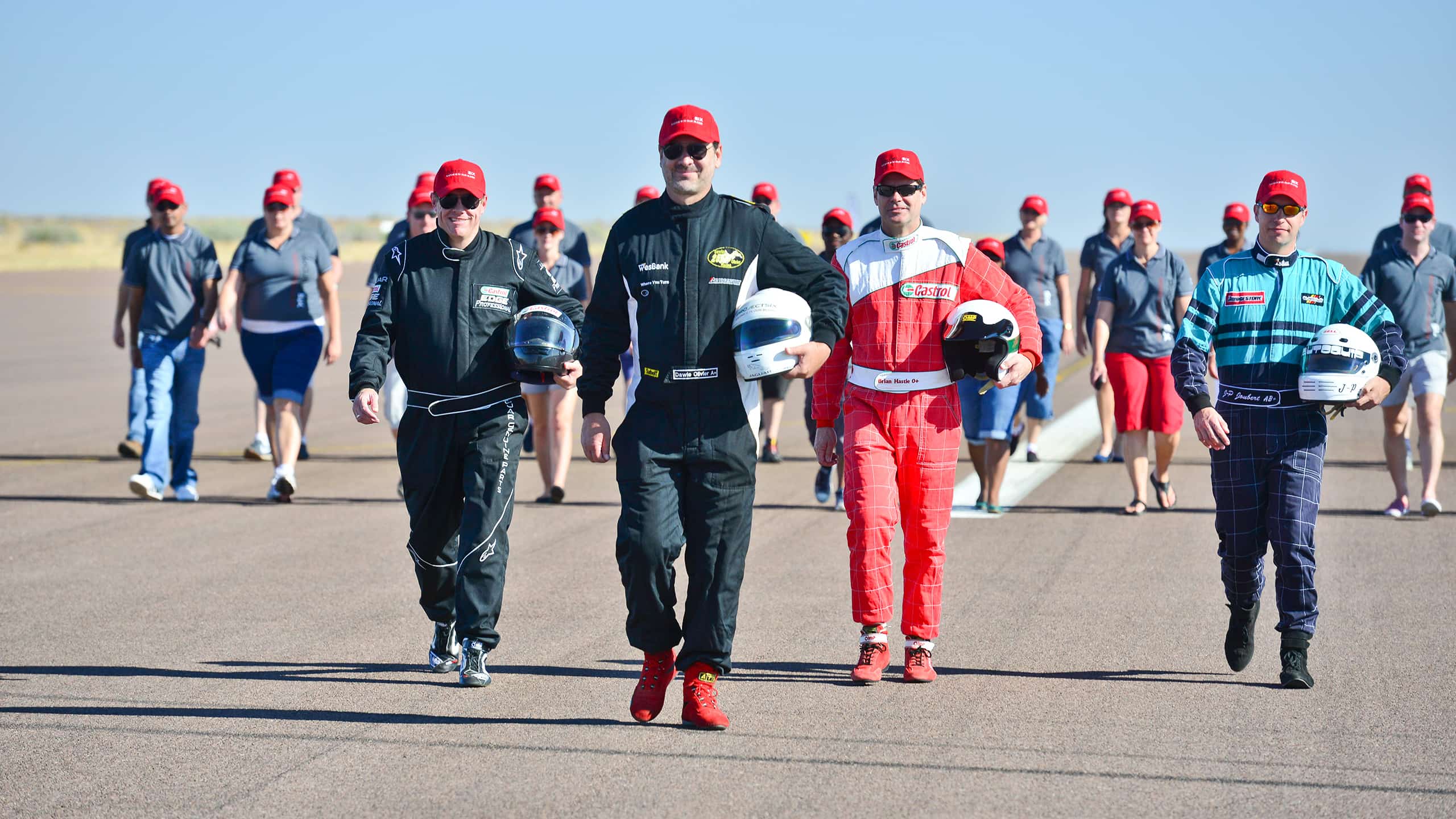 People with racing costumes walking on racing track